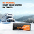 Motorhome in snowy landscape with battery pack for winter RV travel.