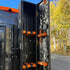 Black and orange tool storage cabinet on a vehicle with trees in the background